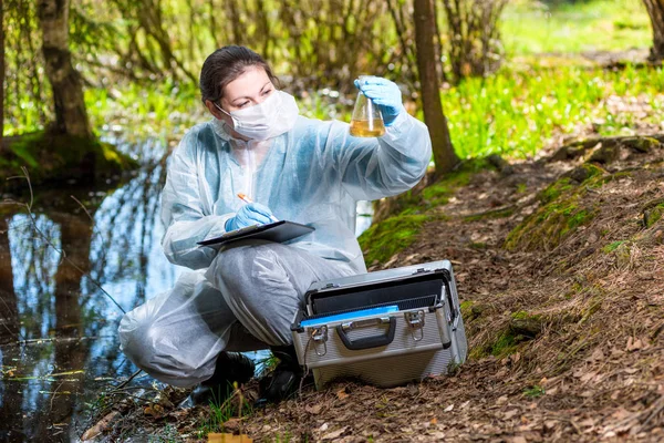 Ekoolog biolog se vzorkem vzorků vody z lesa — Stock fotografie