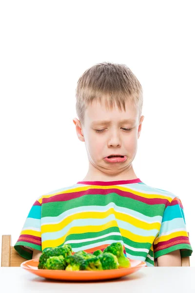 Chłopiec z obawą patrzy na talerz brokułów, portret na białym — Zdjęcie stockowe
