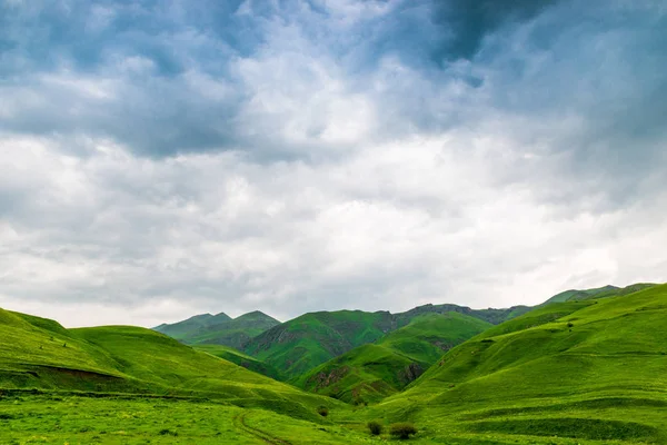 Blå smukke skyer over de grønne maleriske bjerge i Ar - Stock-foto