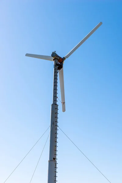 Gerador de energia moinho de vento contra o céu azul — Fotografia de Stock