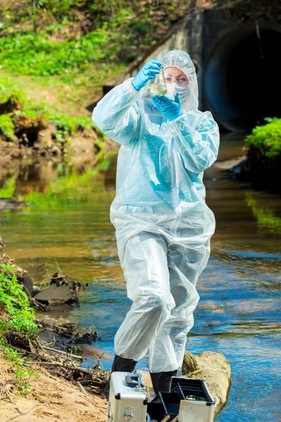 Veszélyes szennyvízcsatorna, egy tudós vesz egy mintát a víz PR — Stock Fotó