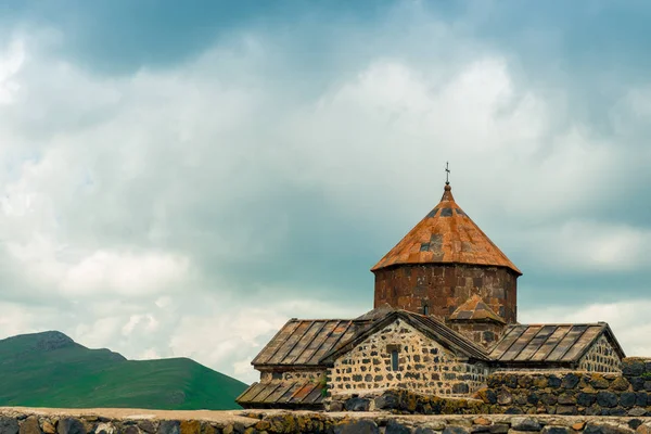 Mosteiro de Sevanavank em um fundo de nuvens de chuva azul escuro, um — Fotografia de Stock