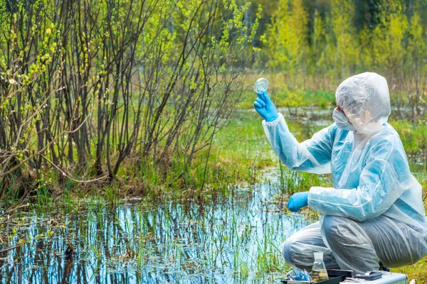 Mulher estuda água e plantas do lago da floresta, compos químicos — Fotografia de Stock
