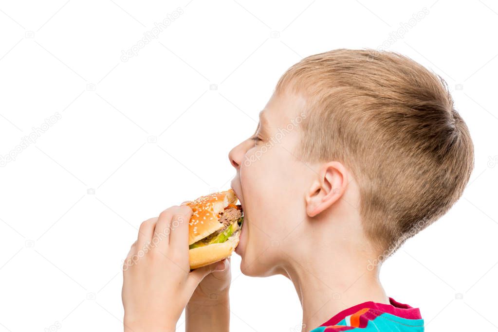 closeup portrait of a hungry boy with a hamburger on white backg