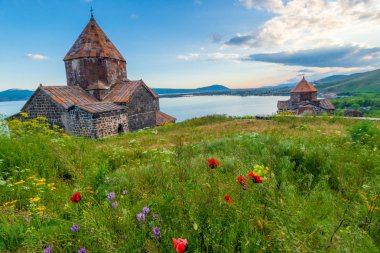 Ancient Christian monastery of Sevanavank and Lake Sevan at suns clipart