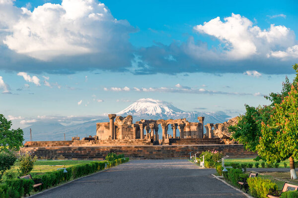 The ruins of the ancient Zvartnots temple on the background of a high snow-capped mountain Ararat, a landmark of Armenia