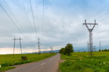 Bulutlu bir günde tarladaki elektrik hatlarının kentsel manzarası