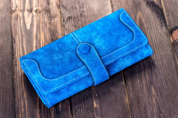 木製の床の上の青い革の女性の財布クローズアップ — ストック写真