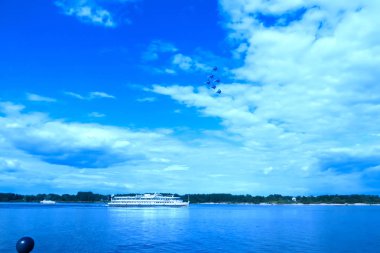 Volga Yaroslavl yakınındaki büyük Rus nehir üzerinde ciddi gökyüzü. Saf mavi gökyüzünde bulutlar. Akrobasi uçan savaş savaşçı