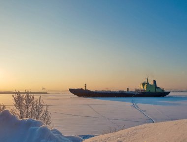 Arkhangelsk. Kuzey Dvina kıyısında güneşli kış günü. Ocak. Arkhangelsk bağlantı noktası fairway buza ticaret gemisi. 