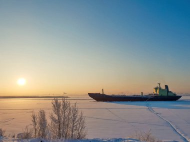 Arkhangelsk. Kuzey Dvina kıyısında güneşli kış günü. Ocak. Arkhangelsk bağlantı noktası fairway buza ticaret gemisi. 