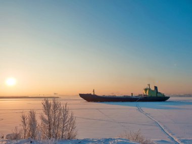 Arkhangelsk. Kuzey Dvina kıyısında güneşli kış günü. Ocak. Arkhangelsk bağlantı noktası fairway buza ticaret gemisi. 