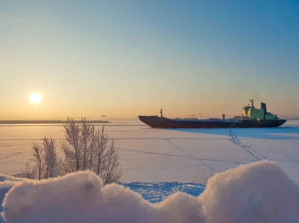 Arkhangelsk. Sunny winter day on the Bank of the Northern Dvina. January. Merchant ship in the ice on the fairway of the port of Arkhangelsk. — Stock Image Arkhangelsk Sunny Winter Day Bank Northern Dvina January Merchant Ship Royalty Free Stock Photos