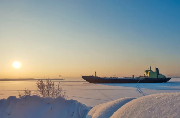 Arkhangelsk. Sunny winter day on the Bank of the Northern Dvina. January. Merchant ship in the ice on the fairway of the port of Arkhangelsk. — Stock Image Arkhangelsk Sunny Winter Day Bank Northern Dvina January Merchant Ship Stock Image