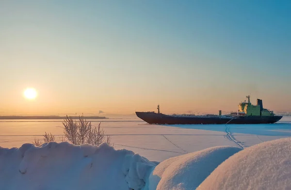 Arkhangelsk. Sunny winter day on the Bank of the Northern Dvina. January. Merchant ship in the ice on the fairway of the port of Arkhangelsk. — Stock Image Arkhangelsk Sunny Winter Day Bank Northern Dvina January Merchant Ship Stock Image