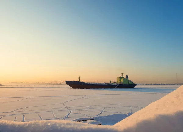Arkhangelsk. Sunny winter day on the Bank of the Northern Dvina. January. Merchant ship in the ice on the fairway of the port of Arkhangelsk. — Stock Image Arkhangelsk Sunny Winter Day Bank Northern Dvina January Merchant Ship Royalty Free Stock Images