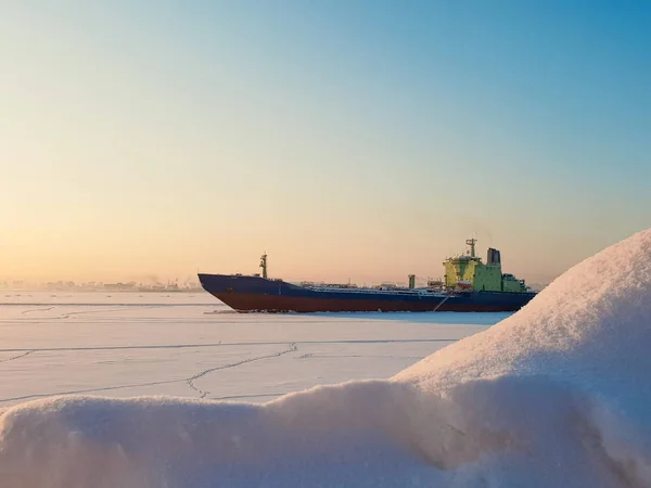Arkhangelsk. Sunny winter day on the Bank of the Northern Dvina. January. Merchant ship in the ice on the fairway of the port of Arkhangelsk. — Stock Image Arkhangelsk Sunny Winter Day Bank Northern Dvina January Merchant Ship Royalty Free Stock Photos