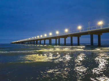 Karadeniz kıyısında sıcak bir yaz gecesi. Anapa, Krasnodar bölgesi. Deniz dalgası, gece. Rıhtımdaki ışıklar