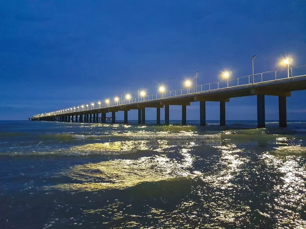 A warm summer night on the coast of the Black sea. Anapa, Krasnodar region. Sea wave, night. lights on the sea pier