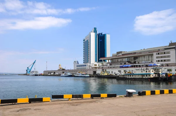 Sea terminal passenger terminal. At the pier boats, tugs, catamaran. A calm sea and a light breeze. On the background is a modern building.