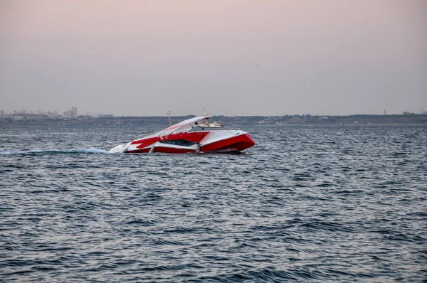 Motor yacht. The color of the yacht is red and white. Black Sea. Turquoise waves. Panorama of the sea landscape.