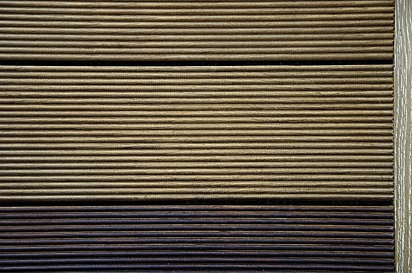 A terrace board with strips. Wood texture. Background brown and black.