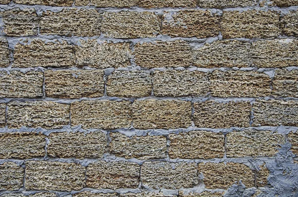 Background and stone texture. Wall. Yellow and gray stone with cement.