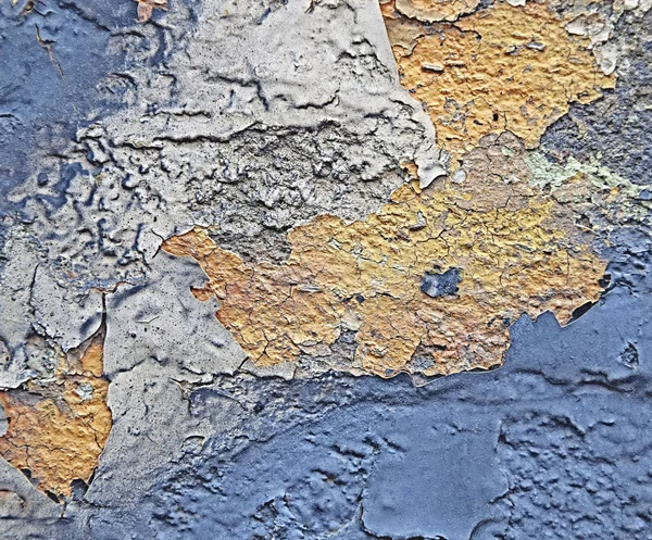 Rust on the iron. The texture and background of cracked blue and yellow paint on the metal.