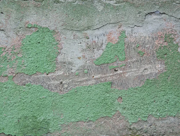 Texture and background of old, damaged concrete, with remnants of green paint plaster.