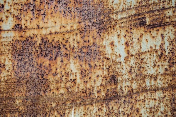 Rust. Texture and background of old rusty metal sheet. Rusty iron, with scratches and paint residue.