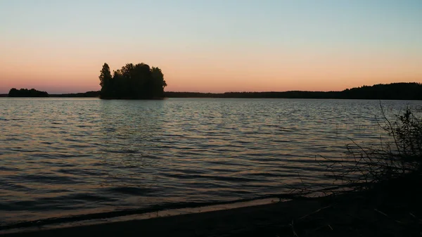 ツリーおよび島が付いている湖の夕日 — ストック写真