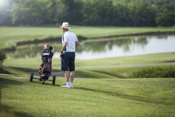 Gracz Golfa Dojrzały Mężczyzna Kapeluszu Pobliżu Jego Koszyka Golf Polu — Zdjęcie stockowe