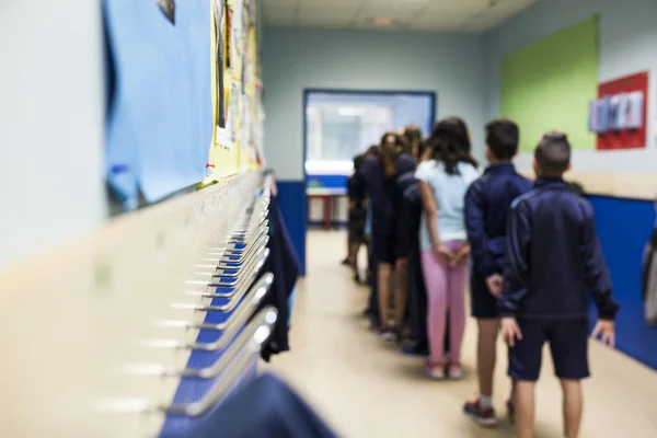Fila Estudiantes Sobre Sus Espaldas Una Sala Escuela Delante Percheros — Foto de Stock