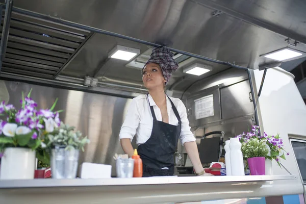 beautiful and young woman working on a food truck