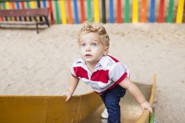 Güzel ve sarışın bir çocuk çalış ve eğlenceli oyun parkında vardır