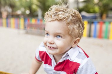 Güzel ve sarışın bir çocuk çalış ve eğlenceli oyun parkında vardır
