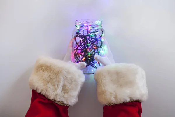 Вид Руки Санта Клауса Держащие Стеклянную Банку Полную Рождественских Огней — стоковое фото