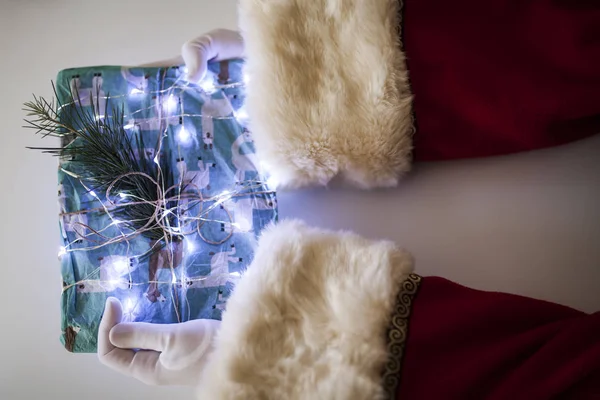 Вид Руки Санта Клауса Подарком Рождественскими Огнями Белом Фоне — стоковое фото