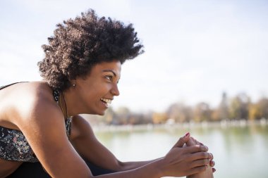 Pratik yoga açık havada ve gülümsemek güzel afro kadın