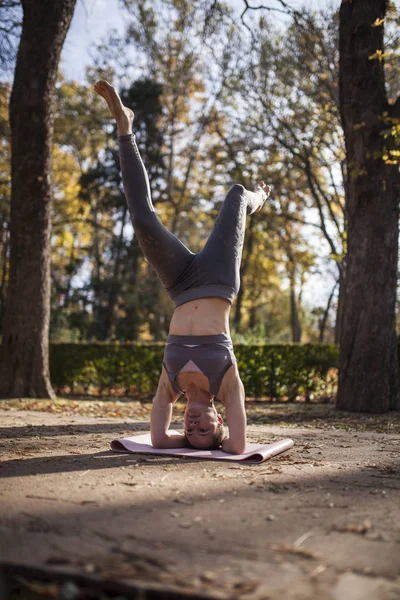 Park yolu üzerinde pratik yoga açık havada, güzel beyaz kadın