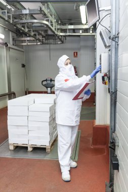 Yükleme iskelesindeki kutu paletini tartan et kesme odası çalışanı