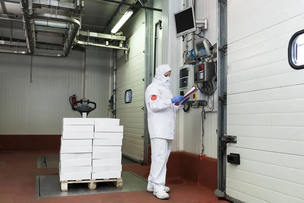 Meat cutting room worker weighing a pallet of boxes at the loading dock