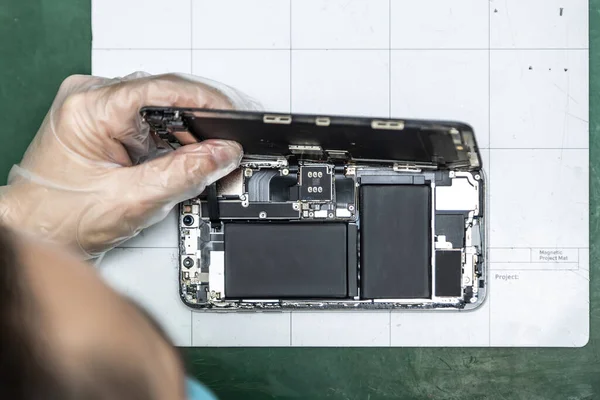 unrecognizable technician repairing smart phone in his repair shop