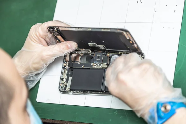 unrecognizable technician repairing smart phone in his repair shop