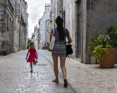 Orleans, Fransa - 11 Ağustos 2018: Küçük sokak trunning çocuk ve yürüyen kadın ve eski yüksek evleri ile nostaljik lambalar ve bitkiler Orleans, Fransa.