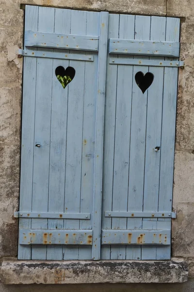封闭的蓝色 旧的百叶窗与心脏在一个老房子白色石膏 桑塞尔白葡萄酒 — 图库照片
