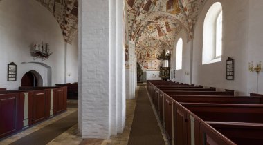 Mon, Danimarka - 17 Eylül 2018: İç Fanefjord Church of resim sergisi ve kırmızı Ahşap banklar renkli tavan ile.