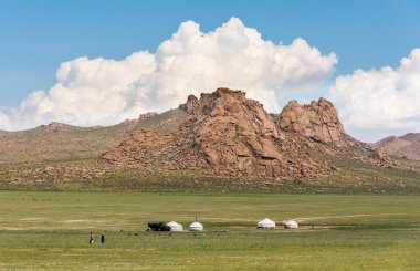 Tolbo, Moğolistan - 4 Ağustos 2019: Moğolistan dağları ve tepeleri arasındaki bir vadide dört yurt, bir kamyon ve iki kadın.