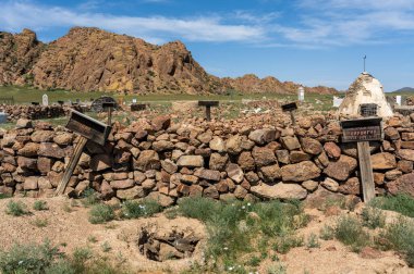 Bayan Olgi, Moğolistan, 5 Ağustos 2019: Moğolistan bozkırında Bayan Olgi yakınlarında dağları ve tepeleri olan mezar taşları ve mezarlık.