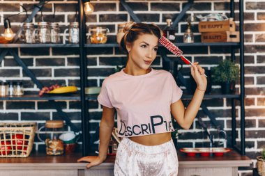 Elinde büyük bir lolipop ile mutfakta Pembeli sarışın rüya gibi kadın